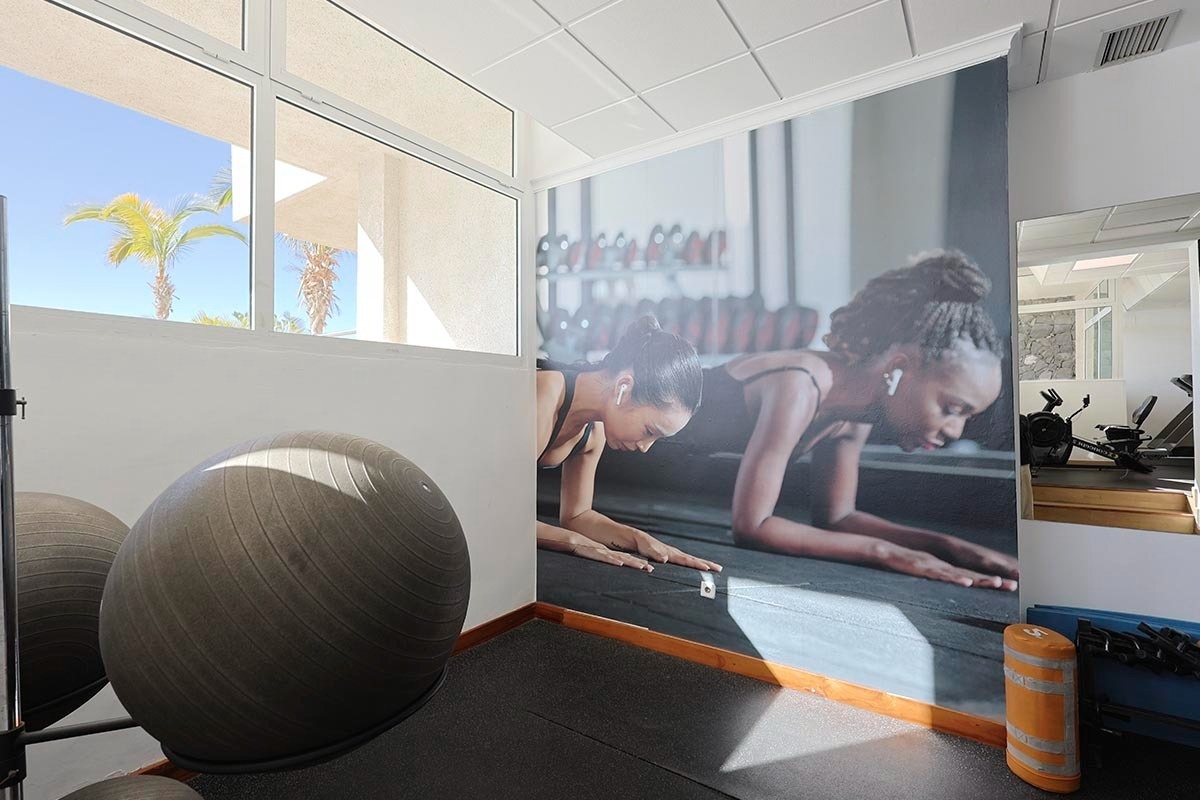 una imagen de una mujer haciendo flexiones en un gimnasio