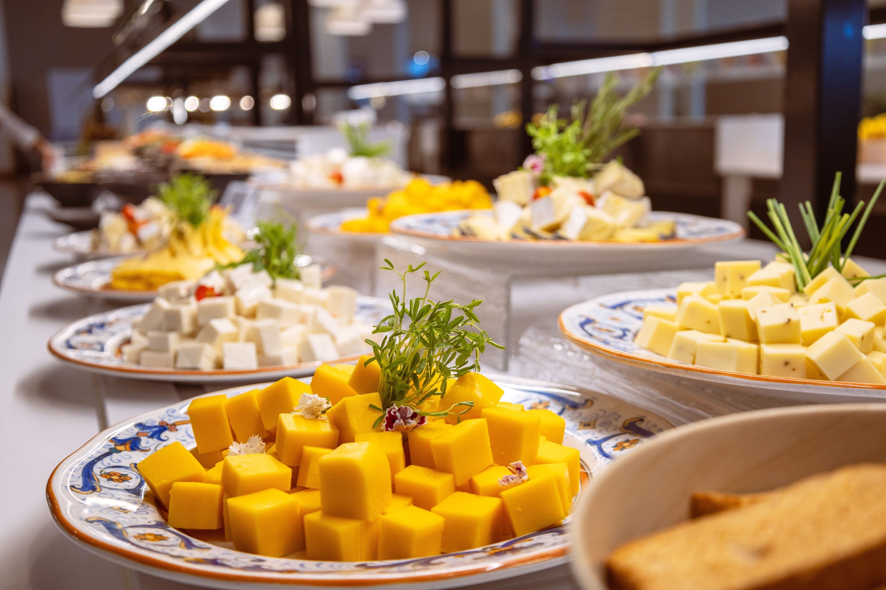 a buffet table with plates of cheese and bread