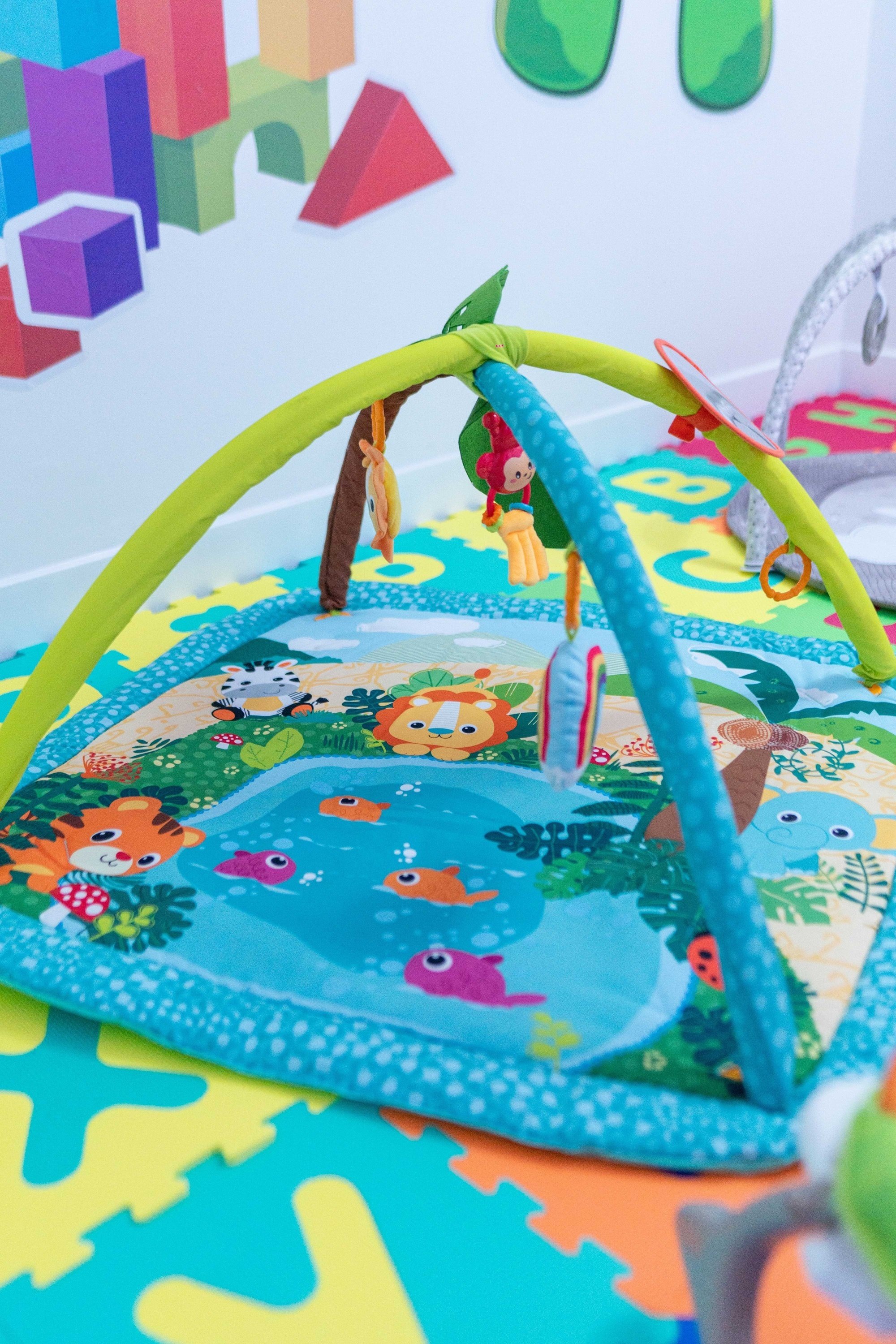 a baby play mat with animals and letters on it
