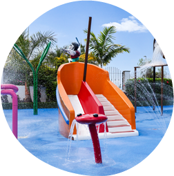 un niño se sienta en la parte superior de un tobogán en un parque acuático .