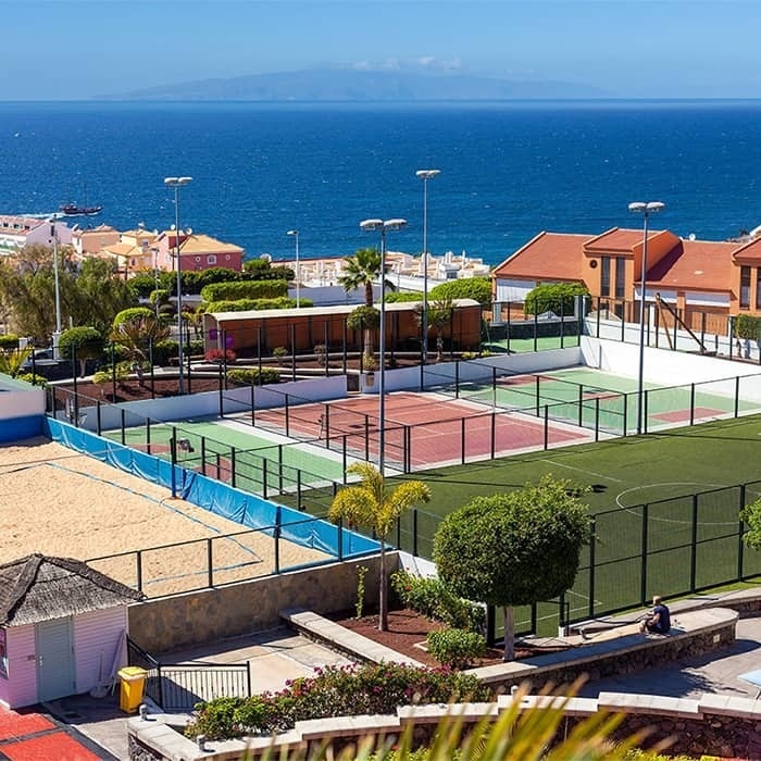 une vue aérienne d' un terrain de tennis avec l' océan en arrière-plan