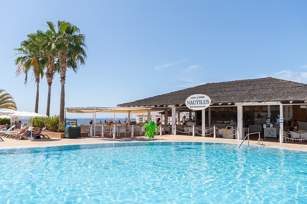 a swimming pool in front of a restaurant called nautilus