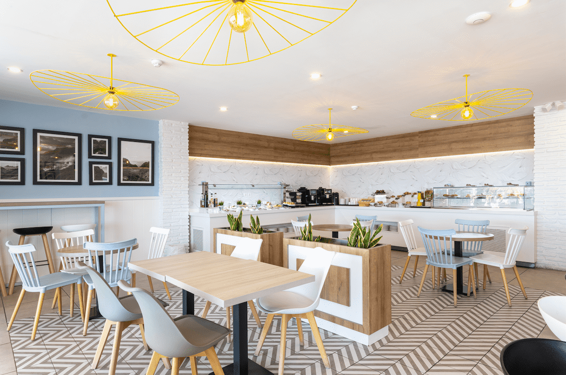 a dining room with tables and chairs and yellow umbrellas hanging from the ceiling