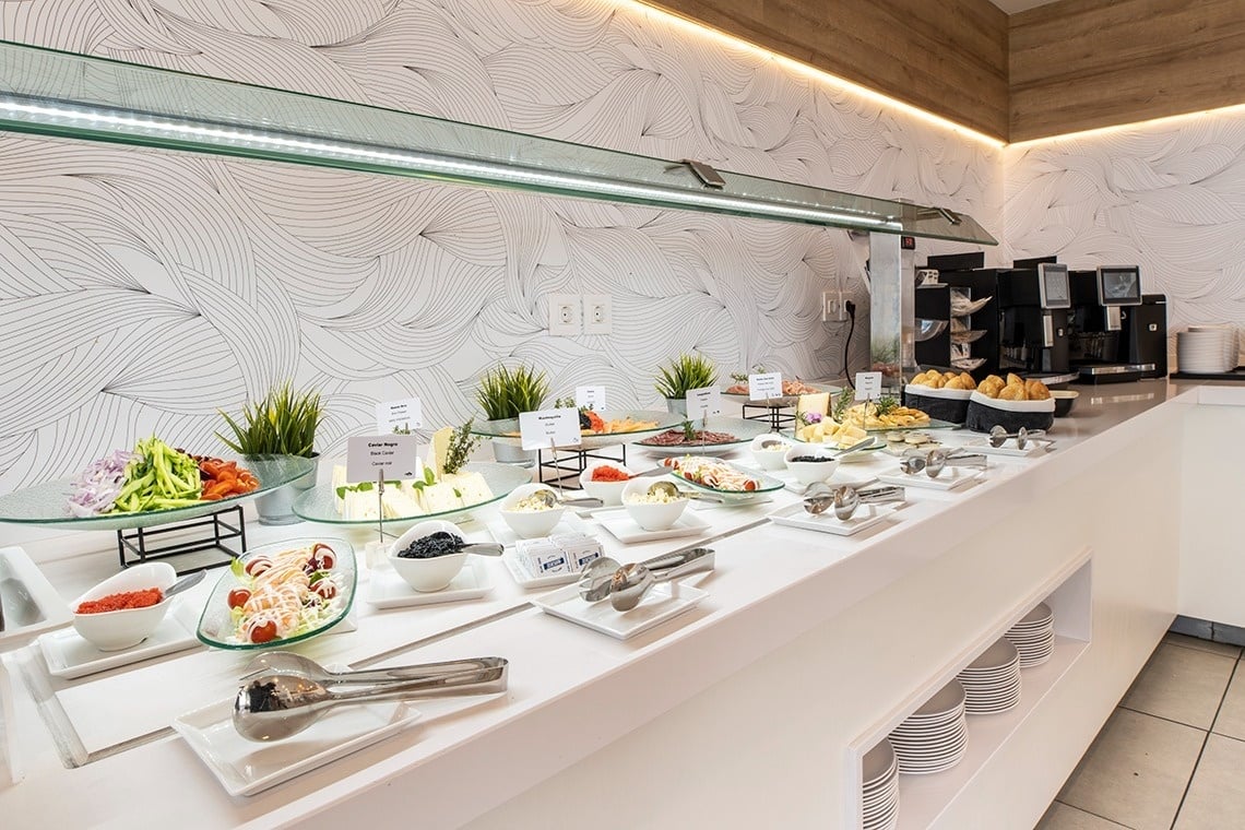 un buffet blanco con platos de comida y una etiqueta que dice ' ensalada '