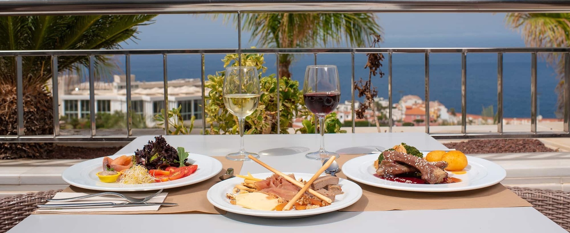 una mesa con platos de comida y copas de vino