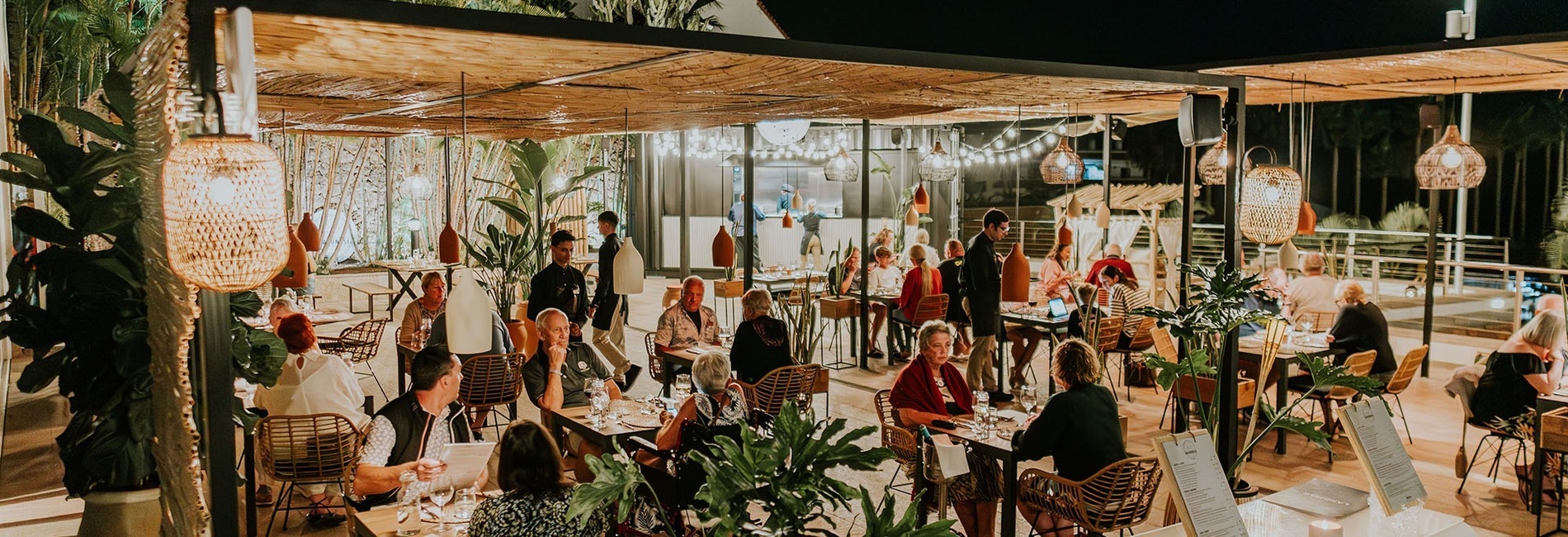 a group of people are sitting at tables in a restaurant
