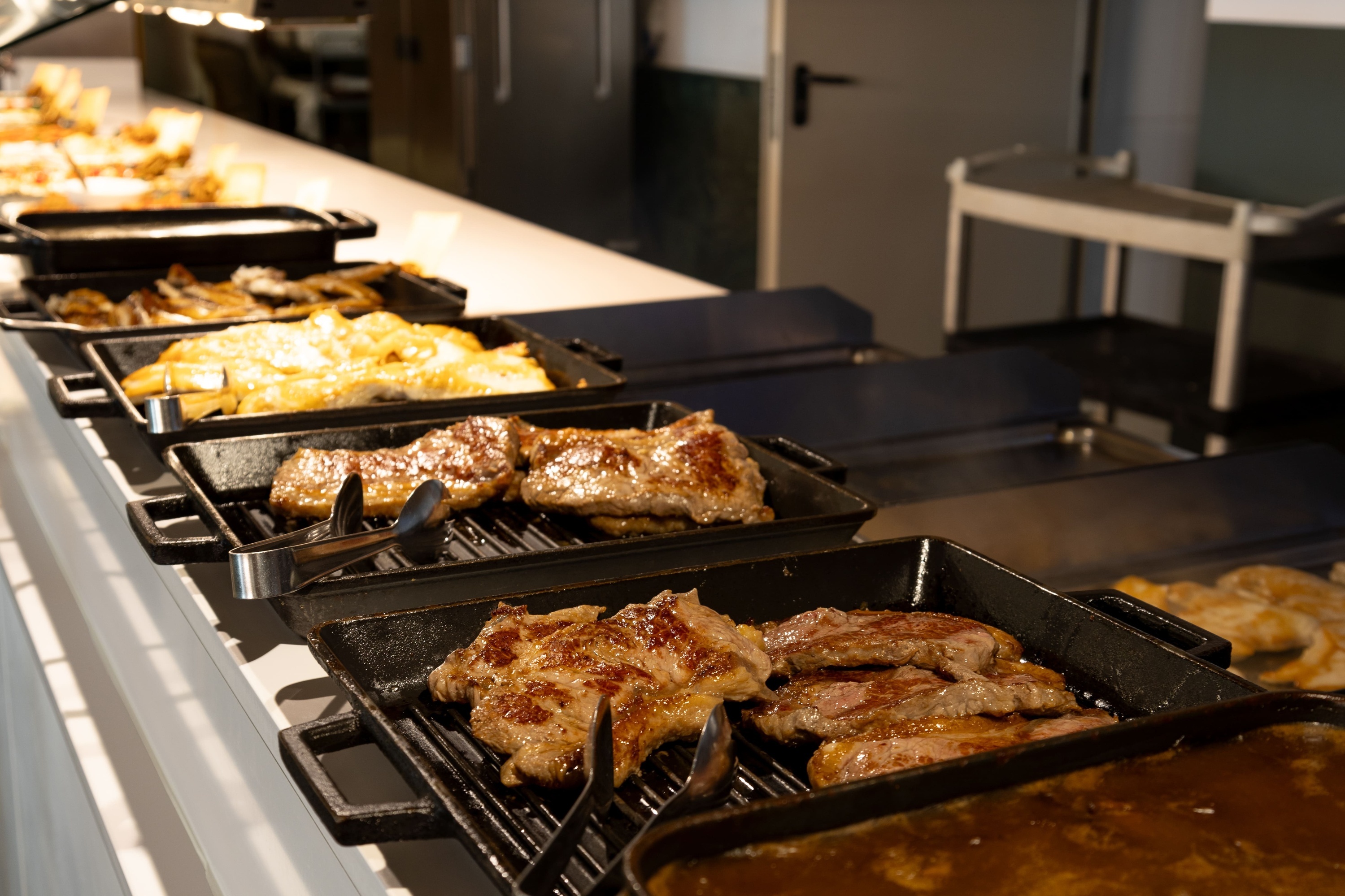 several trays of food are lined up on a counter