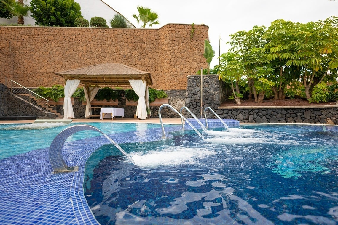 una piscina con un gazebo en el fondo