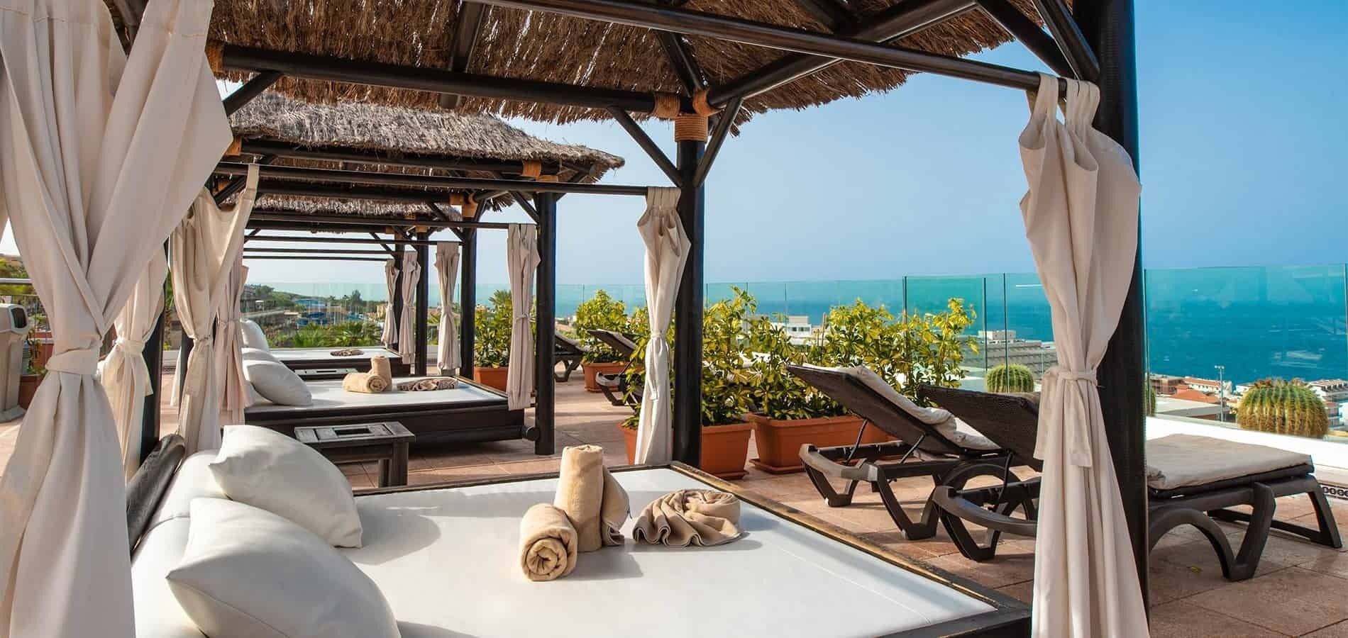 camas y sillas en una terraza con vistas al océano