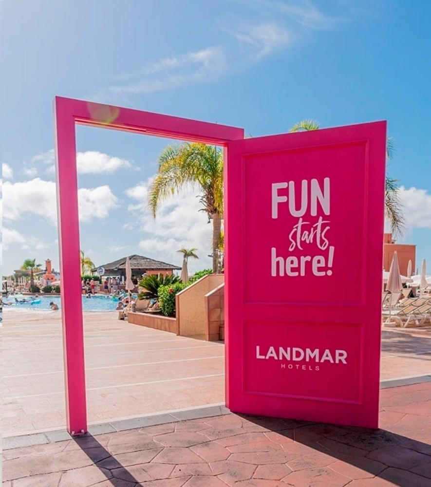 a woman in a striped dress sits in a canopy overlooking the ocean