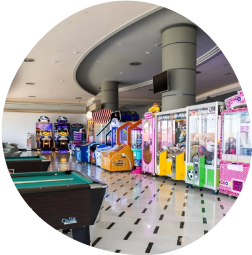 una sala de juegos con mesas de billar y juegos de arcade