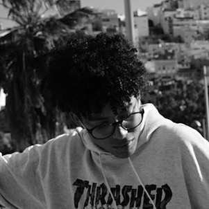 ein schwarz-weißes Foto eines Mannes mit Brille und Hoodie .