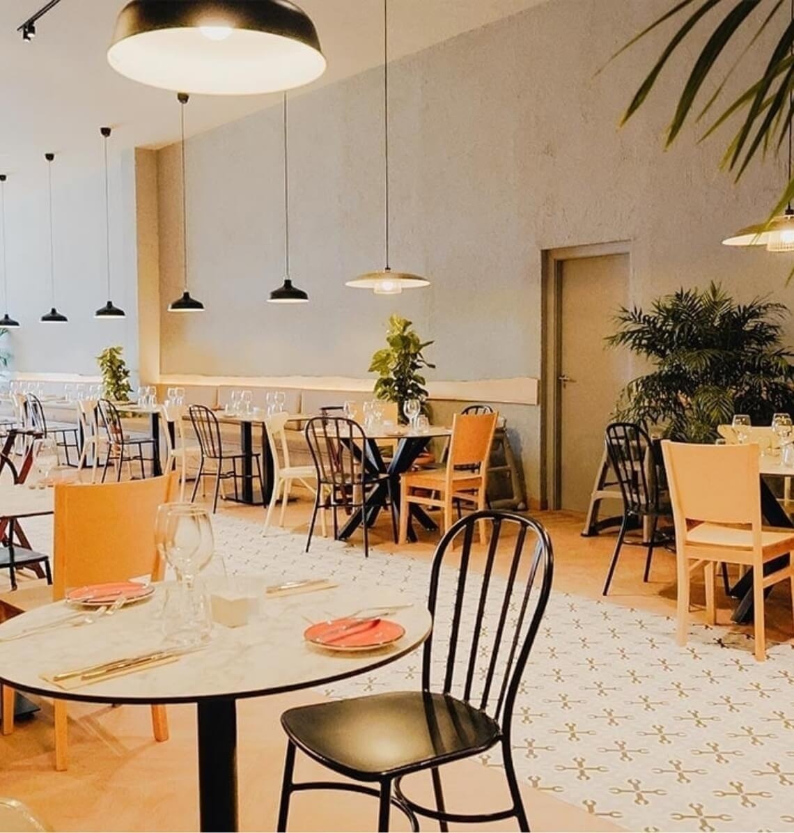 Elegant Landmar interior with tables, chairs, pendant lights, and plants.