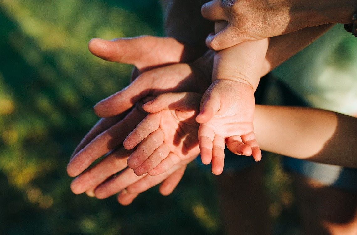 Manos de familia entrelazadas, un símbolo Landmar de amor y unidad.