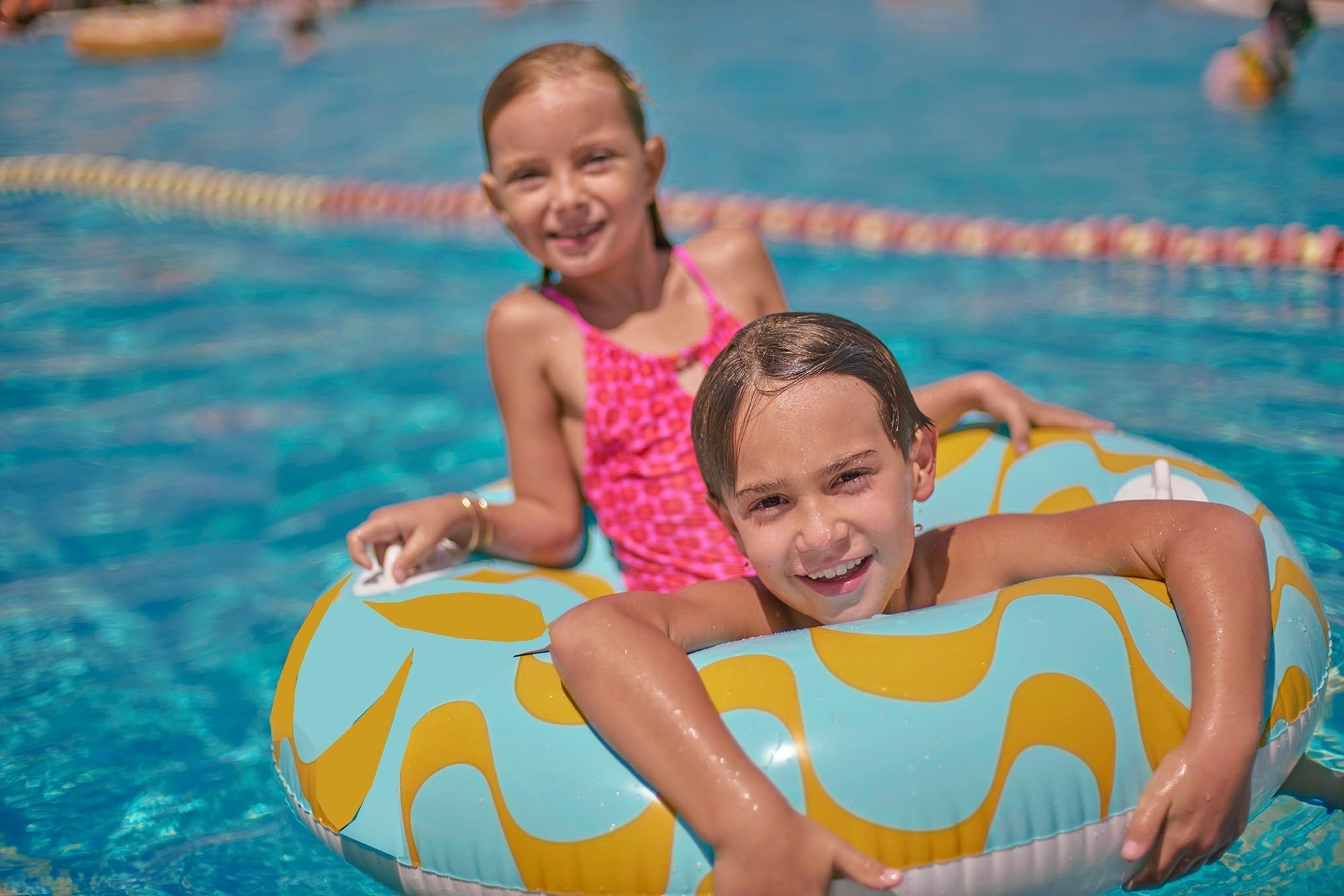 una niña se desliza por un tobogán azul en una piscina