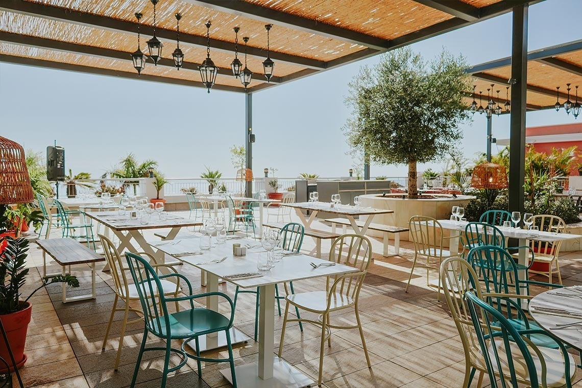 a restaurant with tables and chairs under a canopy
