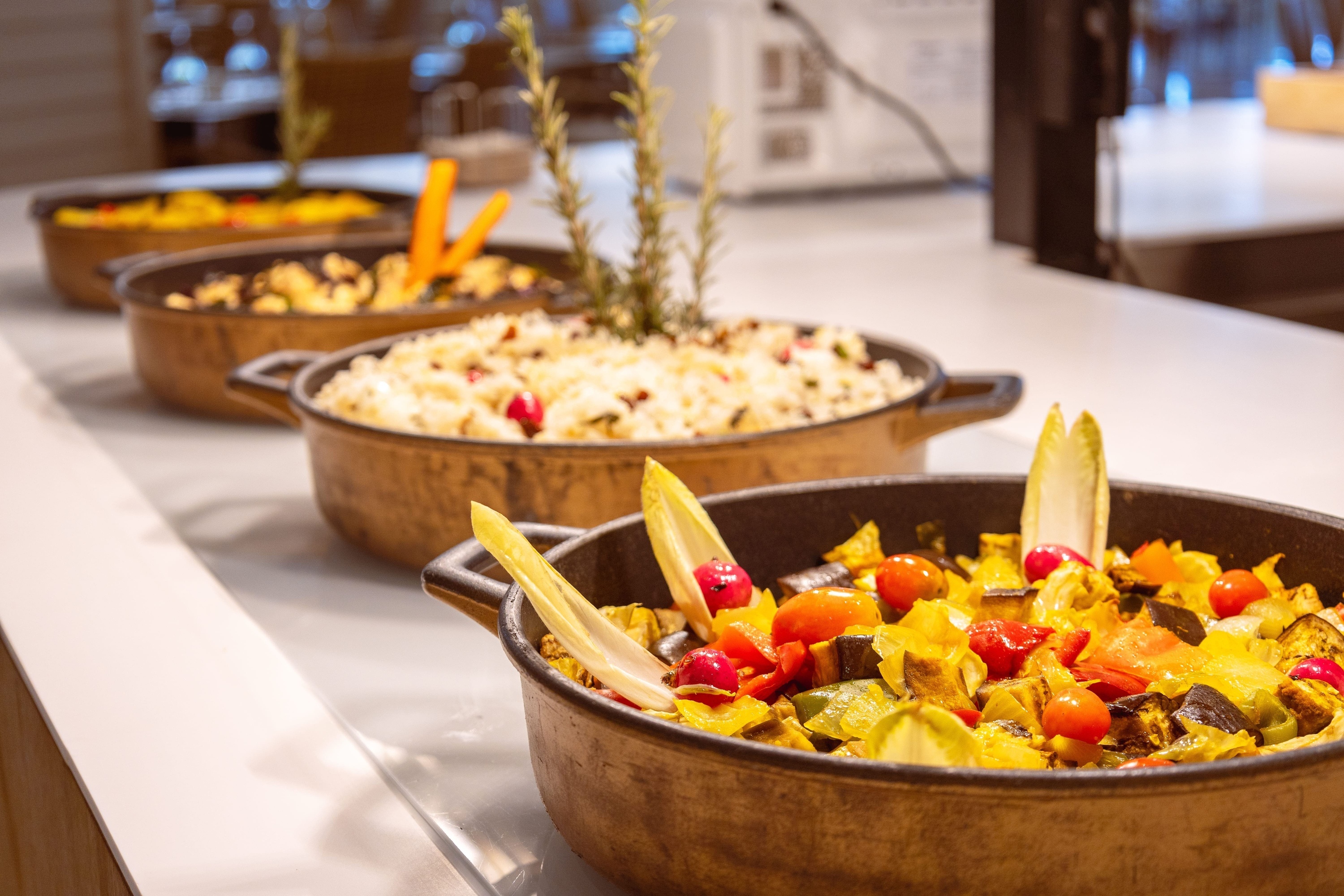 several pots of food are lined up on a counter