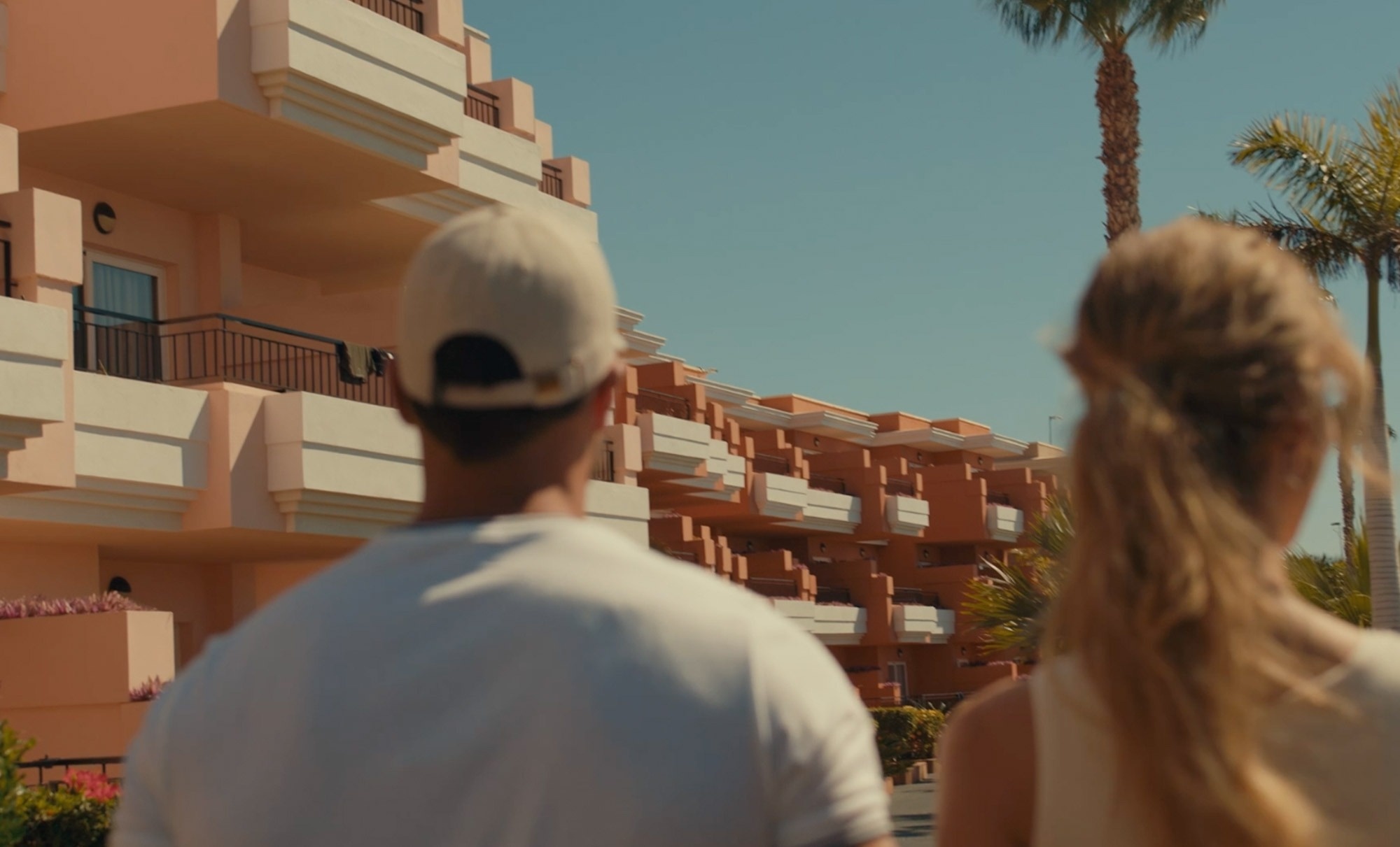 un hombre y una mujer caminan hacia un edificio de apartamentos