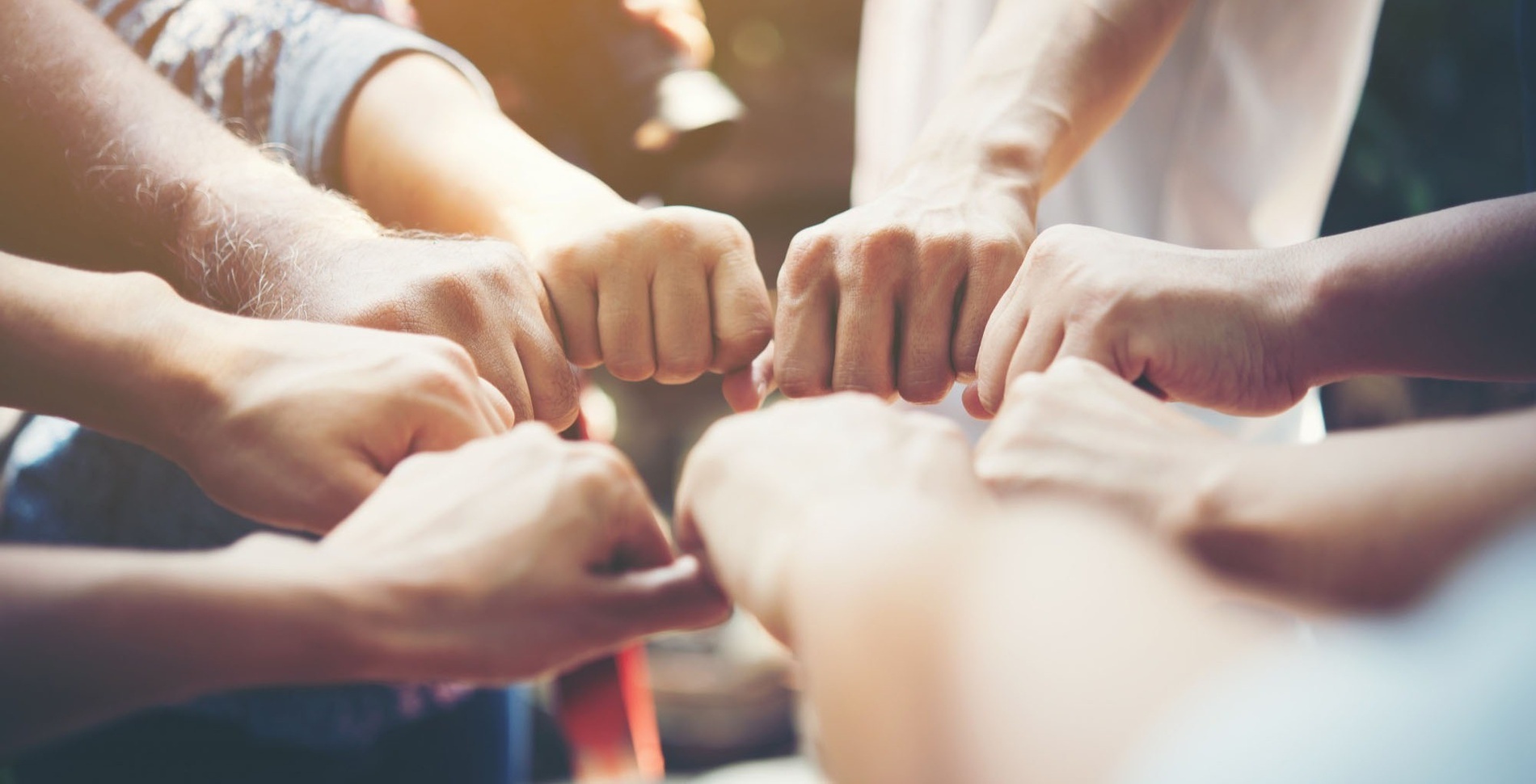 a group of people putting their hands together in a circle