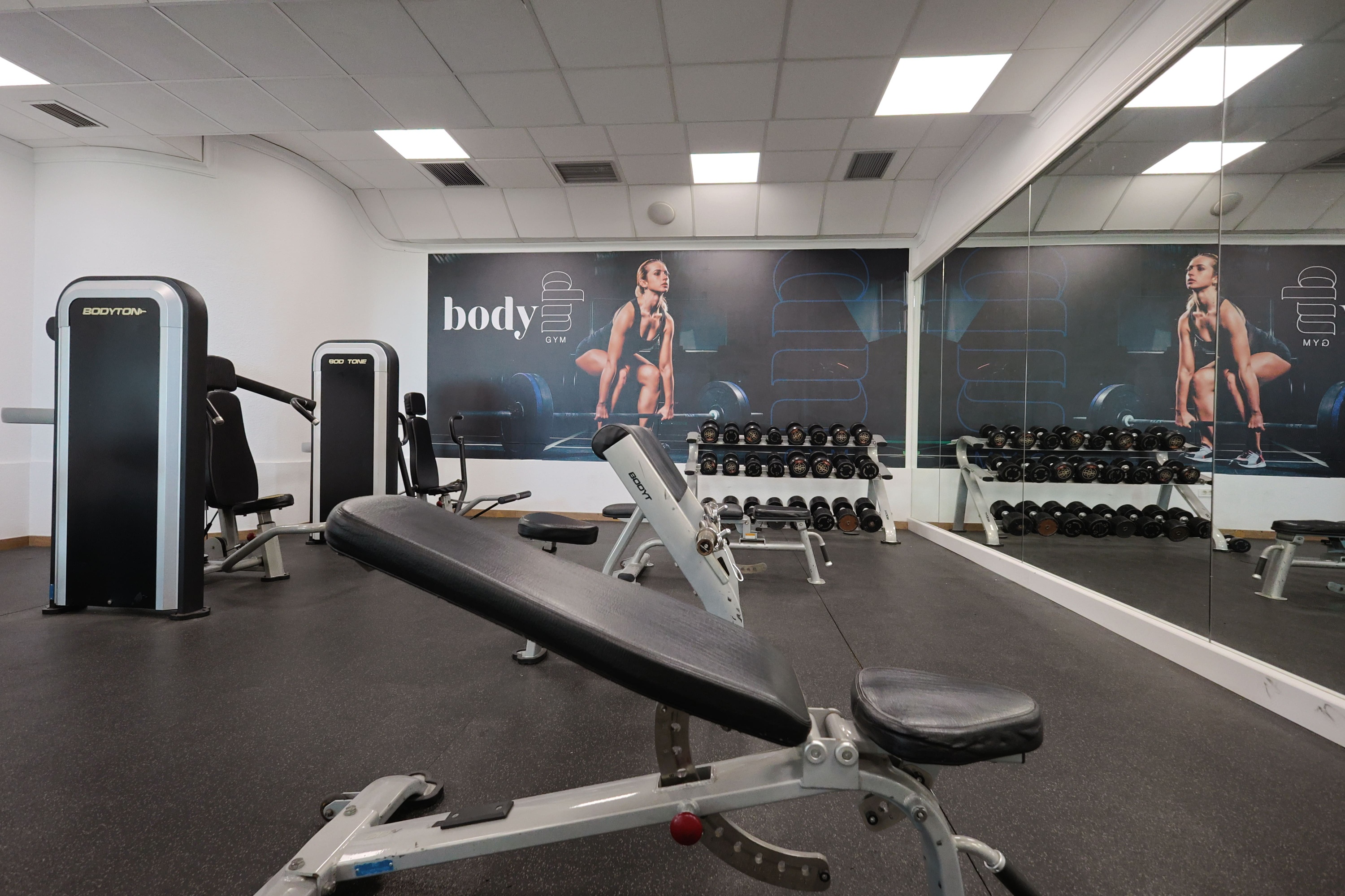 un gimnasio lleno de equipos de ejercicios y una máquina de ejercicios con la palabra assault encima