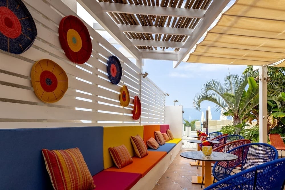 a patio area with colorful chairs and tables