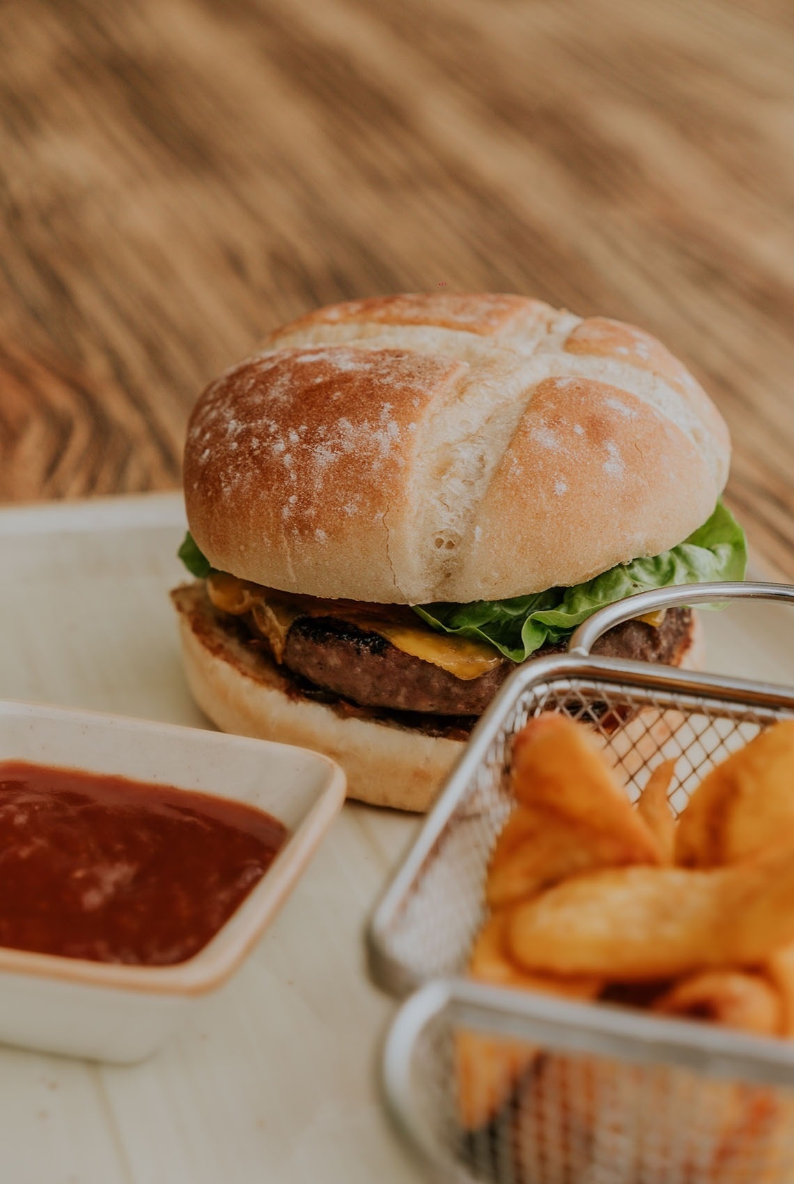 un hamburger est assis sur une table à côté d' un panier de frites