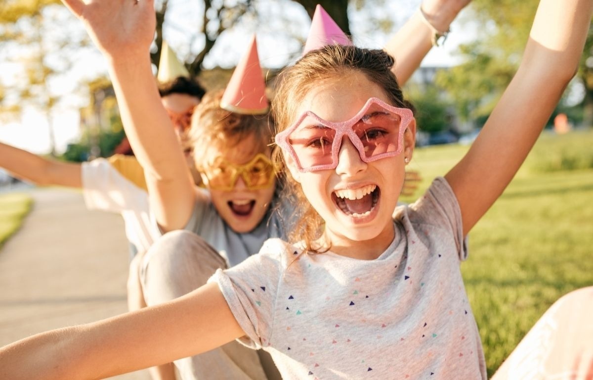une jeune fille porte des lunettes de soleil et des chapeaux de fête