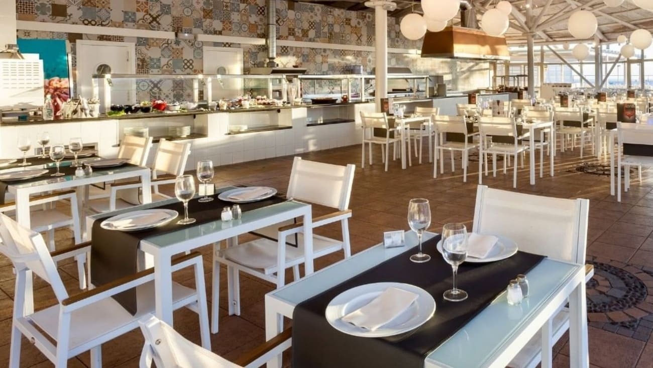 a restaurant with tables and chairs set up with plates and wine glasses