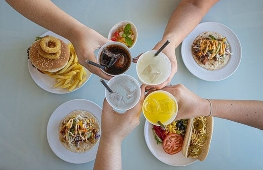 Landmar: Friends toasting with drinks and food at a hotel.