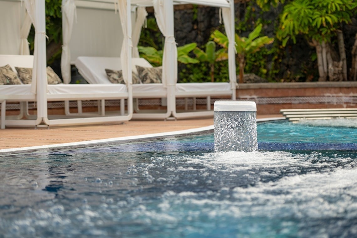 una fuente de agua que sale de una piscina