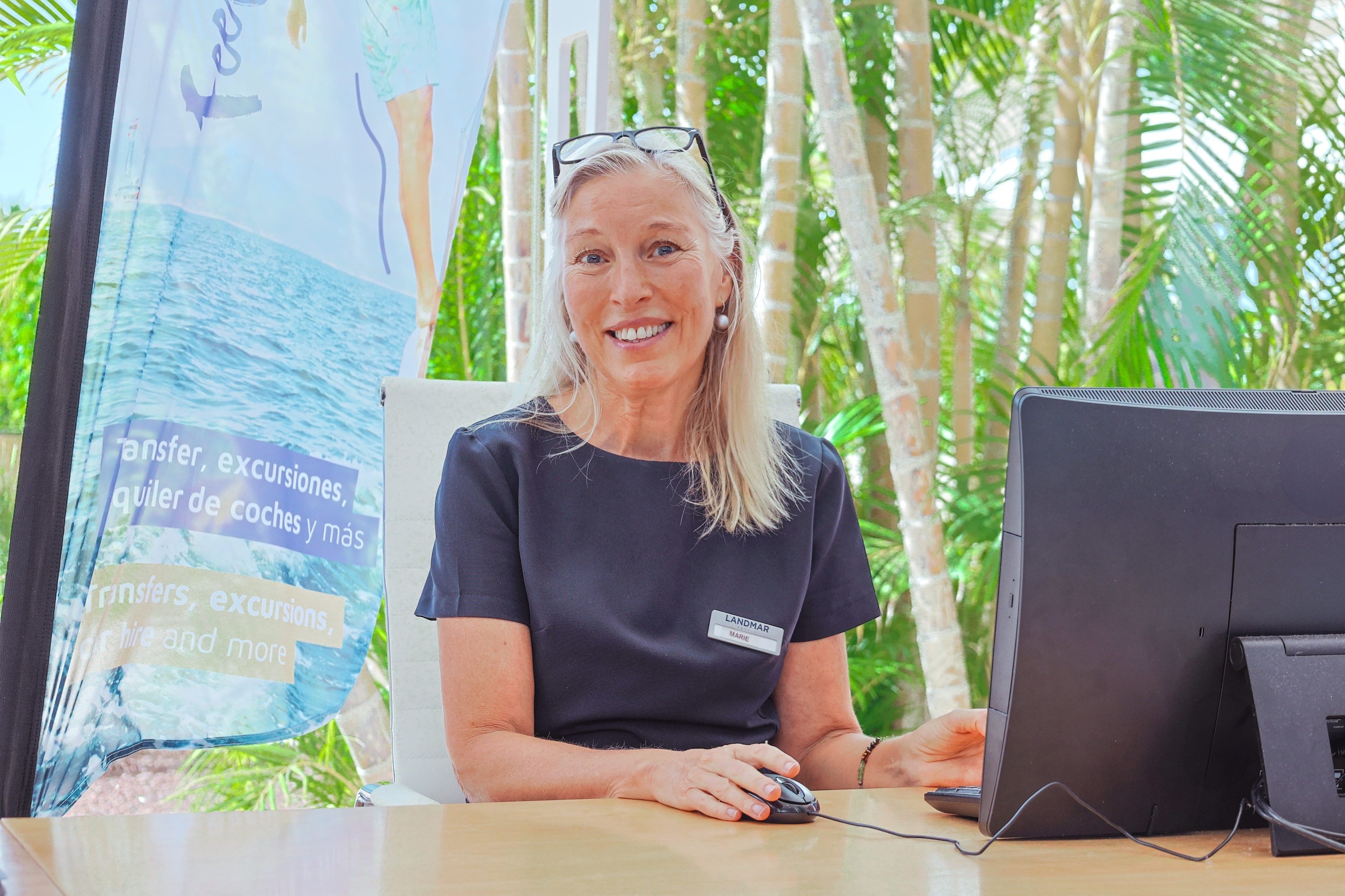 une femme est assise à un bureau devant un ordinateur