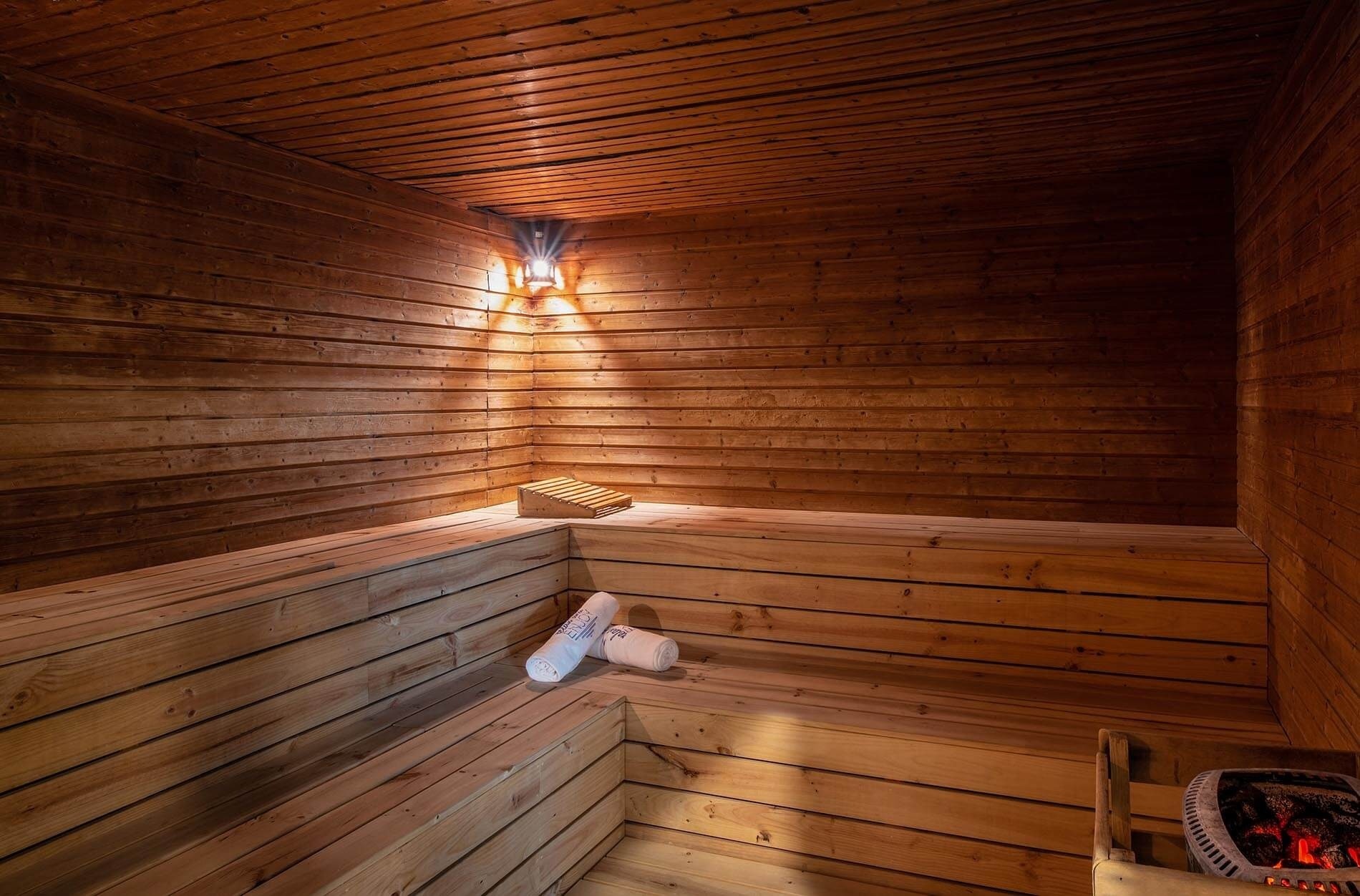 un sauna en bois avec des serviettes blanches sur les bancs