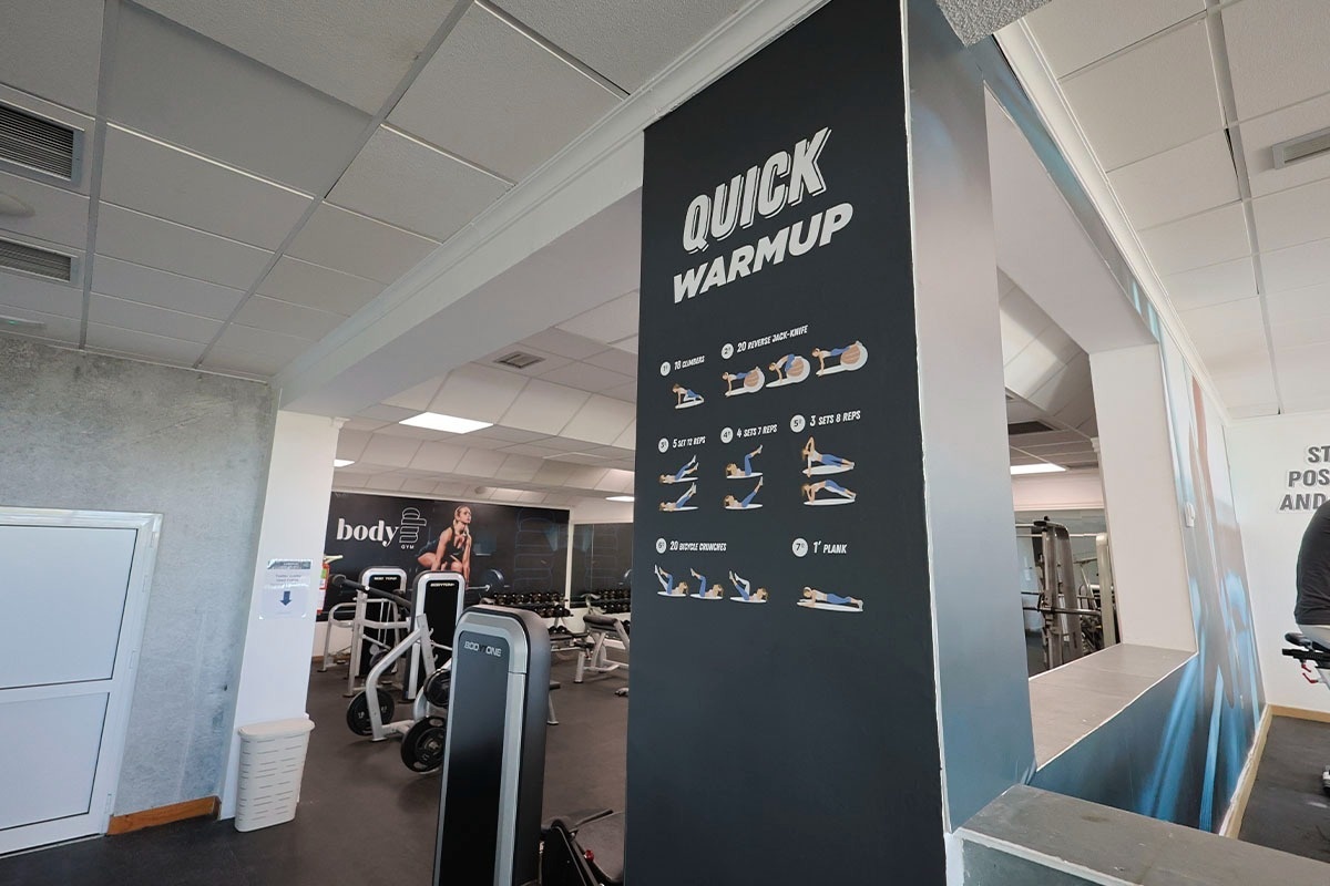 un gimnasio con un cartel que dice calentamiento rápido