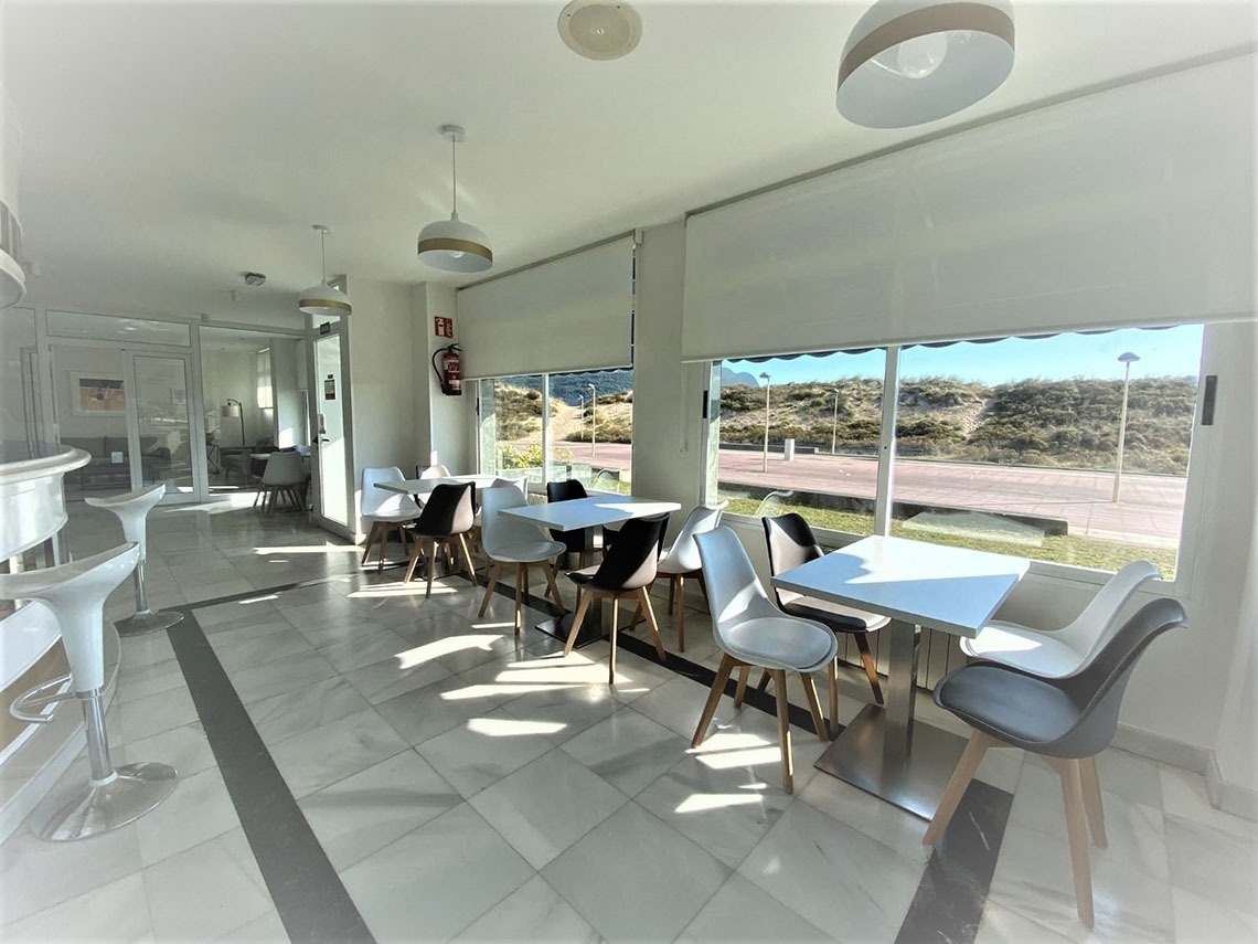 una habitación llena de mesas y sillas con un extintor en la pared