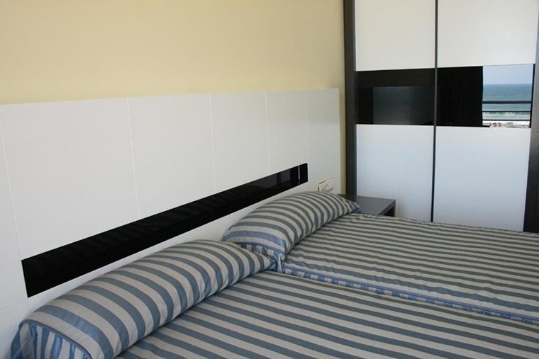 a bedroom with two beds and a striped blanket