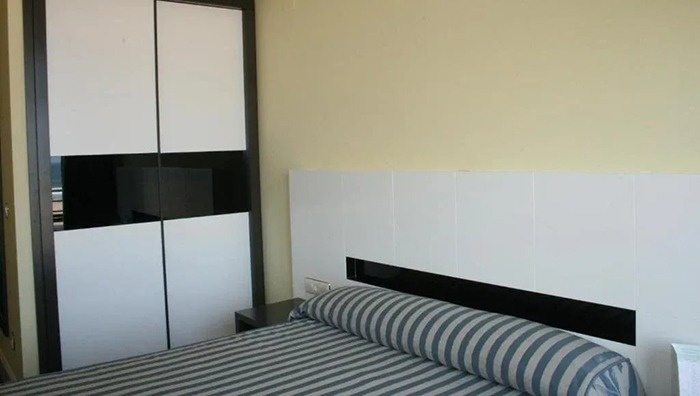 a bedroom with a striped bed and a black and white wardrobe
