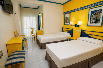 a hotel room with two beds a desk and a mirror