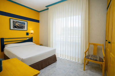 a bedroom with a bed and a picture on the wall