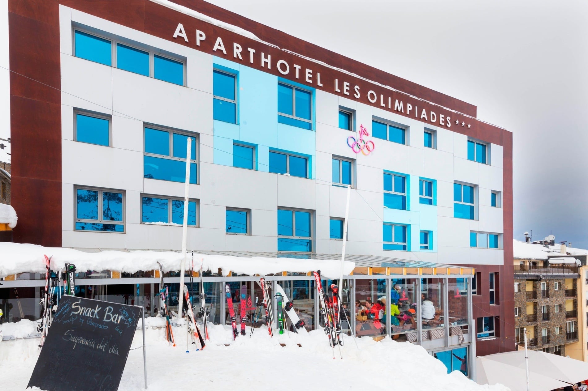 una vista aérea de un pueblo con un río y un edificio con un cuchillo y tenedor en la pared