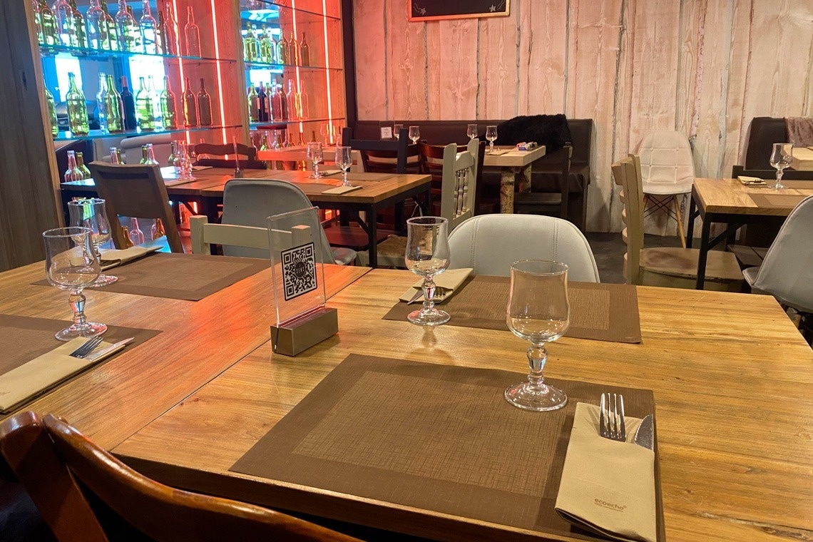 un restaurante con mesas y sillas llenas de comida y copas de vino