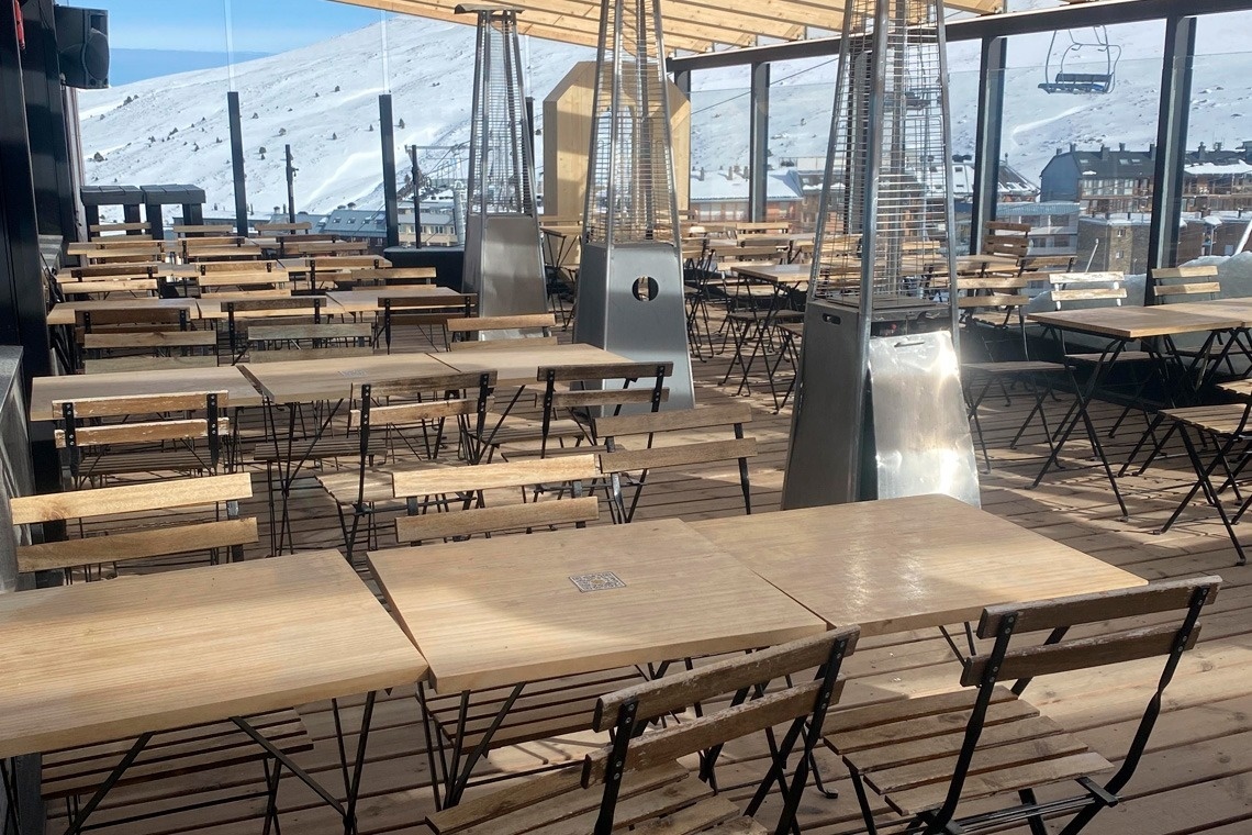 mesas de madera y sillas en un restaurante al aire libre