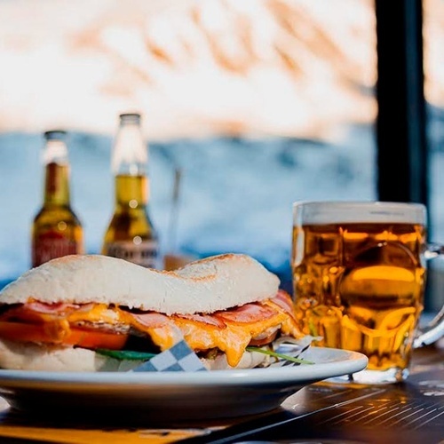 un plato de comida con un sándwich y una cerveza