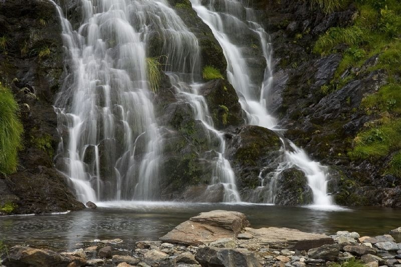 una cascada que cae sobre una roca en un río
