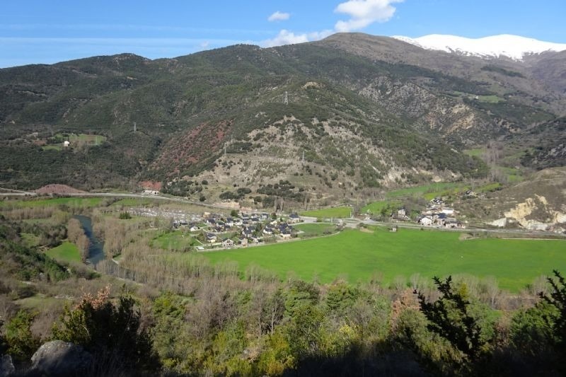 un pueblo en medio de un valle con montañas en el fondo