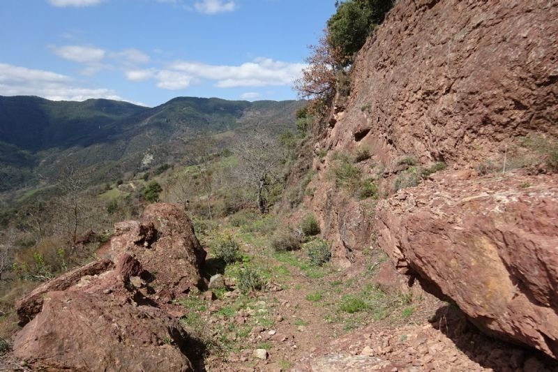 a rocky hillside with mountains in the background