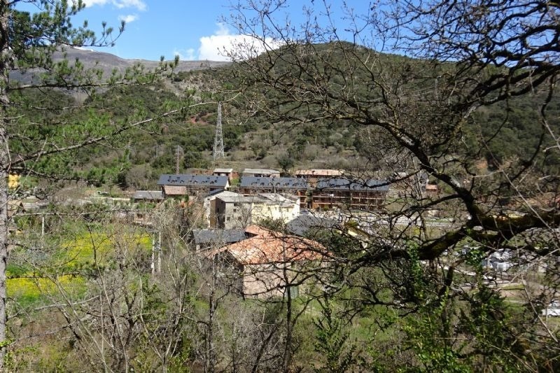 un pequeño pueblo está rodeado de árboles y montañas