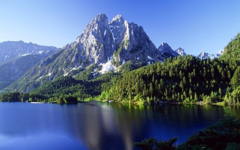 un lago rodeado de montañas cubiertas de nieve y árboles