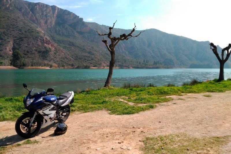 une moto suzuki est garée à côté d' un lac