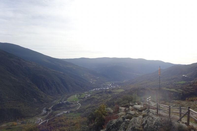 una vista d' un paisatge de montagnes amb una bandera a l' esquerra