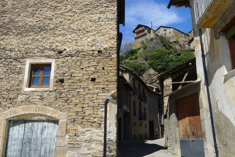a stone building with a window and a narrow street